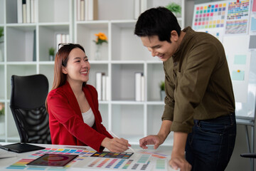 Fototapeta premium Color Selection and Teamwork. Colleagues collaborating on a visual design project in a professional setting.