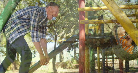 Father playing with child on playground slide, both enjoying sunny day outdoors