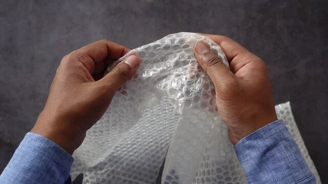 Hands carefully handling bubble wrap in a calm setting