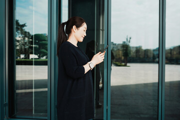 Modern Woman Engaged with Smartphone in Urban Environment