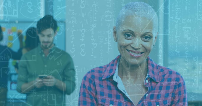 Image of mathematical formulae over woman using tablet