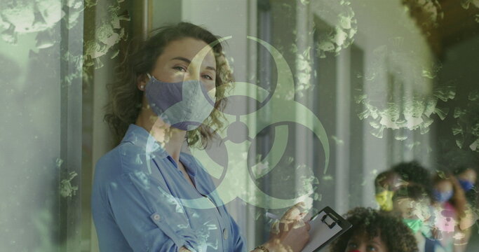 Image of biohazard sign covid 19 cells and female teacher and schoolchildren in face masks