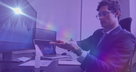 Digital composite image of spots of light against caucasian man using hand sanitizer at office