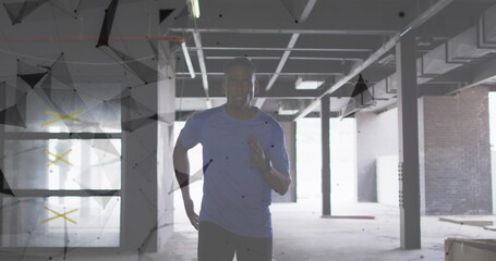 Image of network of connections over man jogging in a abandoned building