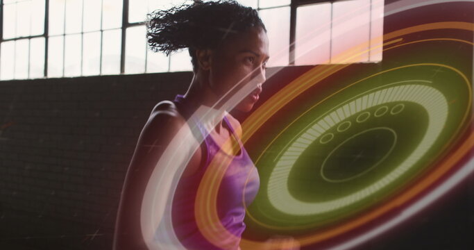 Image of colourful circles over woman jogging in an abandoned building - Powered by Adobe