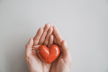 hands holding red heart, heart health insurance, charity volunteer donation, CSR responsibility,...