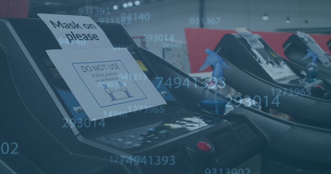 Image of mask on please coronavirus sign on treadmill exercising equipment in gym