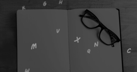 Image of letters falling over notebook and glasses