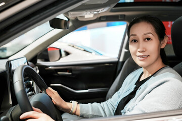 Confident Woman Experiencing the Latest Car Technology in a Showroom