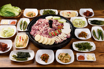 Duck bulgogi and various vegetables on a pot lid brazier