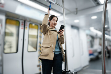 Modern Commuter Using Smartphone in Subway with Luggage