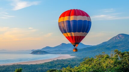Naklejka premium Colorful Hot Air Balloon Floating Over Scenic Mountain Landscape at Sunrise with Beautiful Ocean View