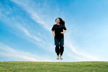 Joyful Woman Running Outdoors Under a Clear Blue Sky
