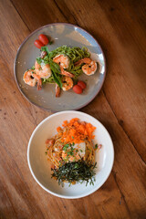 delightful presentation of spaghetti dishes featuring pesto spaghetti with shrimp, cherry tomatoes, and roasted seaweed, alongside vibrant plate of spaghetti topped with shrimp, seaweed, eggs