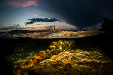 Rocky shoreline under dramatic sky, Sydney.