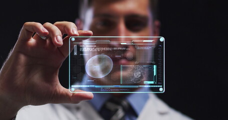 Image of male scientist holding interactive screen with medical data processing