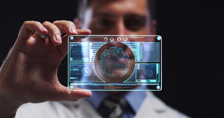 Image of male scientist holding digital screen with covid 19 cell