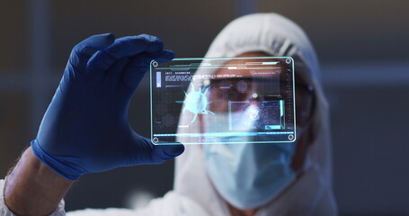Image of male scientist holding digital screen with covid 19 cell