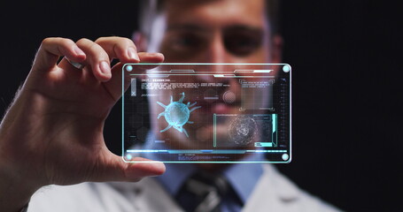 Image of male scientist holding digital screen with covid 19 cell