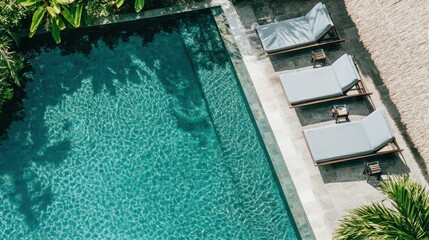 Serene Outdoor Pool Area with Loungers Surrounded by Lush Greenery