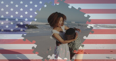 Jigsaw puzzle over american flag against african american couple embracing each other at the beach