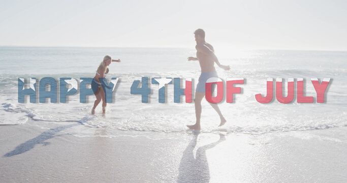 Image of happy 4th of july text with american flag pattern over couple splashing in sea