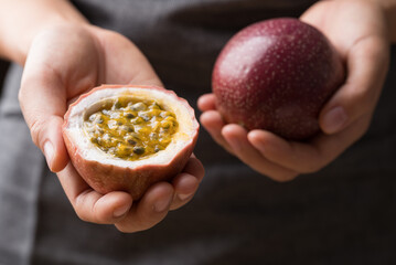 Fresh passion fruit holding by hand, Tropical fruit, Healthy eating