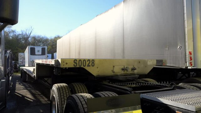 Step deck trailer and other trailers for semi-trucks on the parking lot. Stabil shoot
