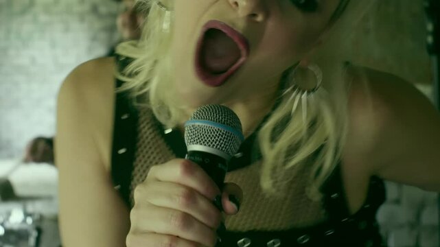 Blonde female vocalist passionately singing with band, performing rock music in grungy abandoned industrial space, radiating raw musical energy and emotion