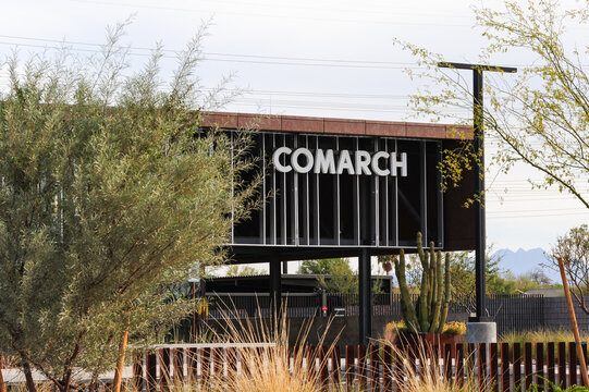 Comarch IT campus exterior with branded sign, steel architecture, desert landscaping, and security perimeter, representing global enterprise software and data services infrastructure