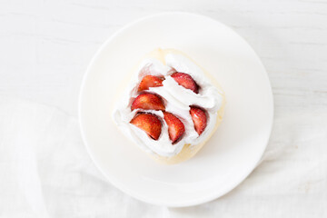 Crepe cake topped with fresh cream and strawberries.