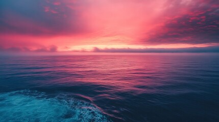 Dramatic pink and purple sunset over the ocean with clouds
