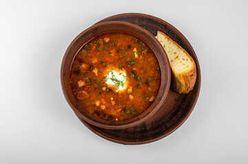 Traditional Ukrainian borscht in a rustic clay bowl, served with sour cream and fresh dill, accompanied by a slice of homemade bread. Classic Slavic cuisine and comfort food	