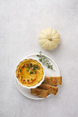 Pumpkin hummus with olive oil in white bowl and flat bread, copy space, top view