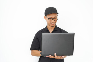 A man wearing a black shirt and a black hat is holding a laptop