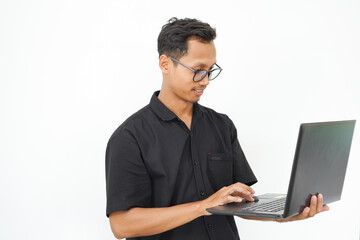 A man wearing glasses is sitting in front of a laptop