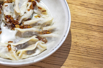 eating dumplings with meat and fried onions with a fork, a national traditional dish of Ukraine