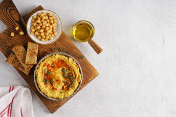 Pumpkin hummus with olive oil , chickpeas and flat bread on wooden board, copy space, top view