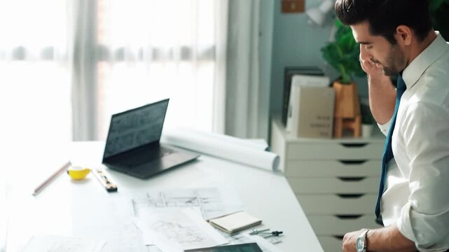 Architect engineer using laptop planning house design at office while sitting at meeting table with blueprint and equipment scatter around.Skilled civil engineer working at blueprint. Alimentation.