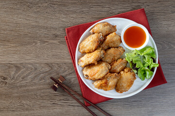 Crispy fried chicken wings on top corner of wooden table