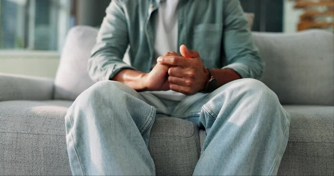 Anxiety, nervous and man fidget with hands on sofa with stress, trauma or emotions in living room at home. Mental health, worry and person stimming with panic attack with phobia, overthinking or fear