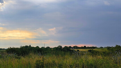 Fototapeta premium cloudy colorful clouds with sun rays over the rural landscape