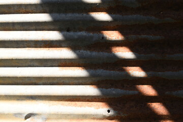old zinc metal roof background with sunlight, construction industry