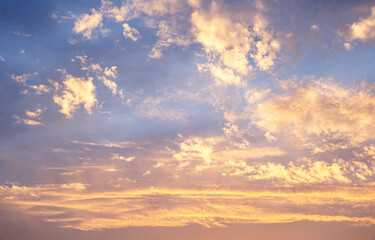 Sky clouds sunset background. Stunning view of golden, lilac and pink clouds and blue sky