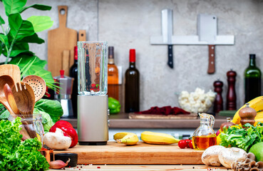 Healthy vegan eating, cooking, food blogging banner background with blender with bananas for smoothies on wooden board on cozy kitchen with wooden table, kitchenware and utensils