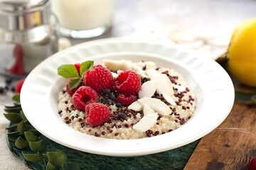 Quinoa porridge with raspberry and coconut flakes for breakfast