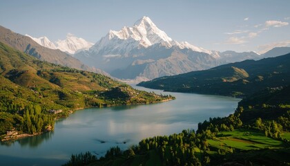 Mountain range with peaks covered in snow, overlooking a lake in a rural landscape