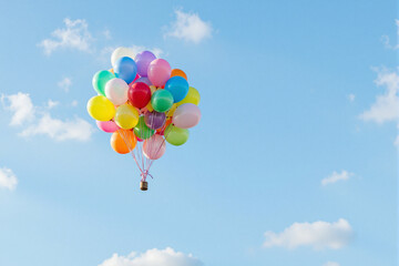 Obraz premium Colorful balloons floating in the blue sky with clouds 