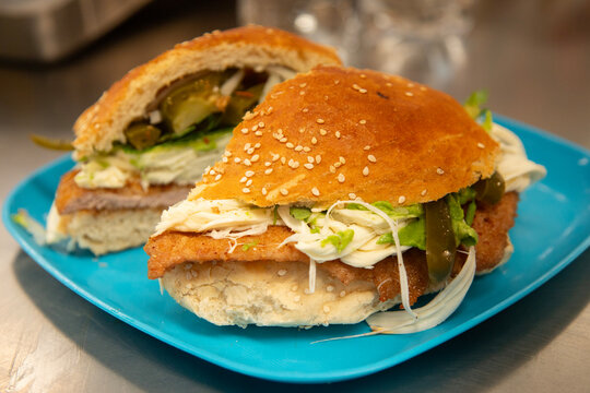 Cemita Poblana. A traditional Mexican sandwich with breaded pork and chipotle chili, quesillo cheese, and papalo leaves.