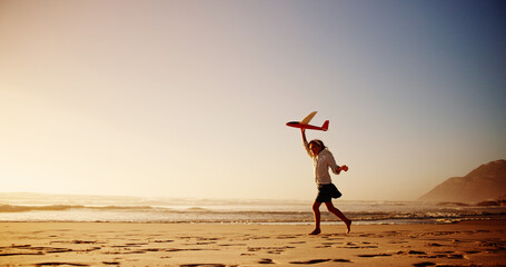 Child, beach and playing with airplane toy for flying game, sunset fun or imagination travel on holiday. Mockup space, girl kid and running at ocean with fantasy flight, vacation freedom or adventure